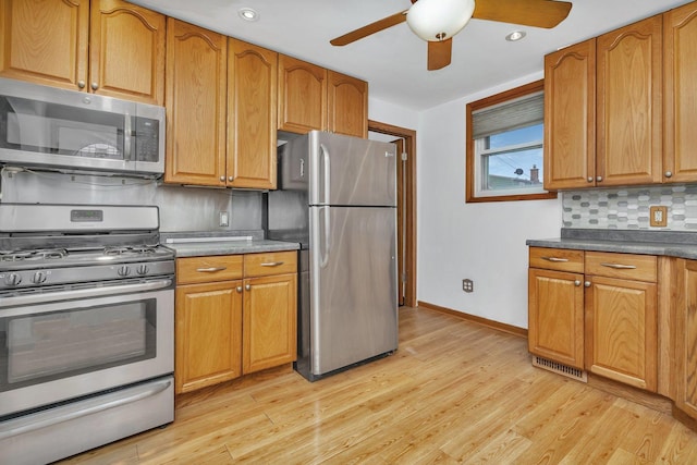 kitchen featuring tasteful backsplash, ceiling fan, light hardwood / wood-style floors, and appliances with stainless steel finishes