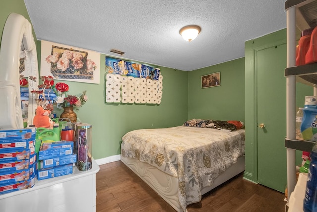 bedroom featuring dark wood-type flooring and a textured ceiling