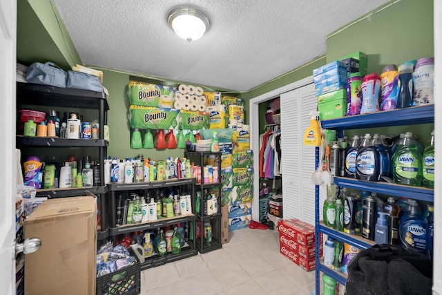 interior space featuring light tile patterned flooring and a textured ceiling