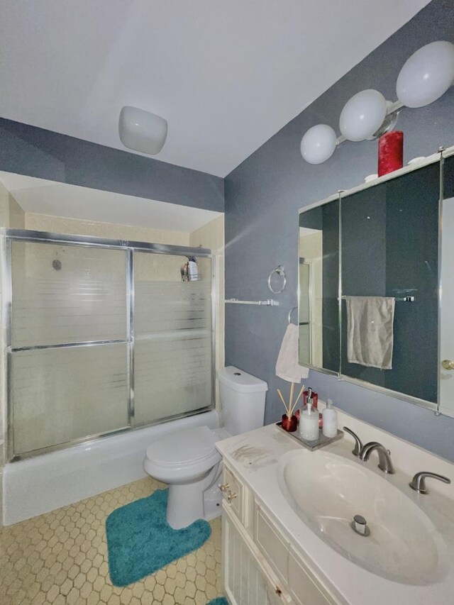 full bathroom with vanity, toilet, combined bath / shower with glass door, and tile patterned floors