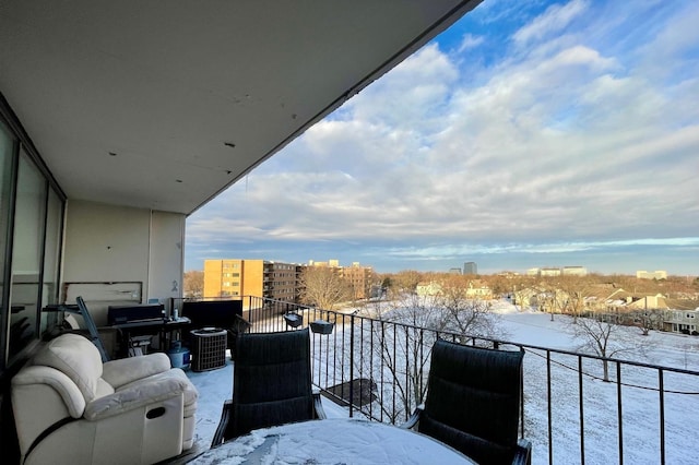 snow covered back of property featuring central AC