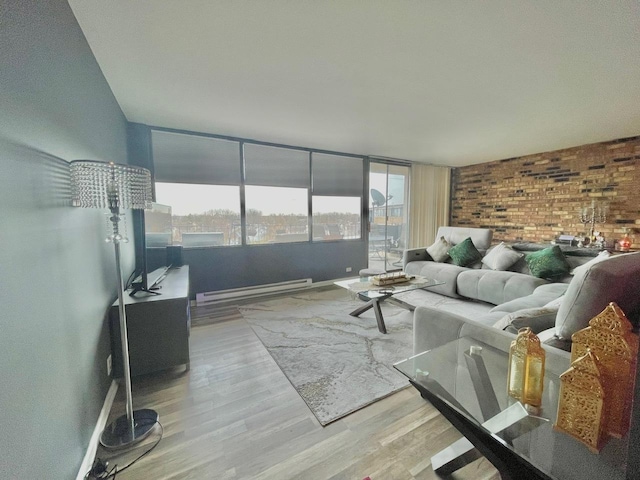 living room with light hardwood / wood-style floors, plenty of natural light, a baseboard radiator, and brick wall