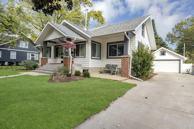 view of front facade with covered porch, a garage, an outbuilding, and a front lawn