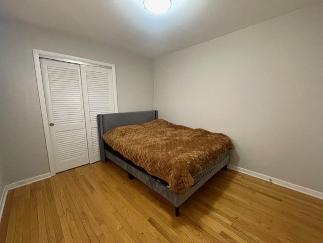 bedroom with light hardwood / wood-style flooring and a closet