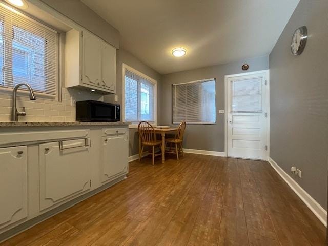 kitchen featuring white cabinets, tasteful backsplash, dark hardwood / wood-style floors, and sink