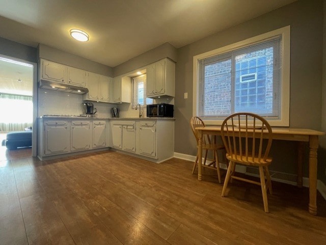 kitchen featuring decorative backsplash, dark hardwood / wood-style floors, and white cabinetry