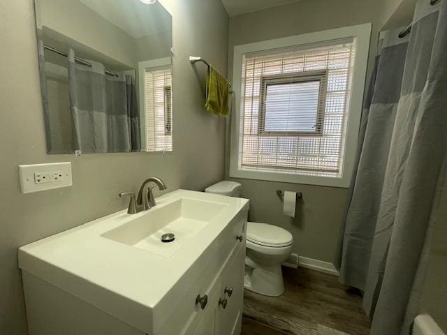 bathroom with wood-type flooring, vanity, and toilet