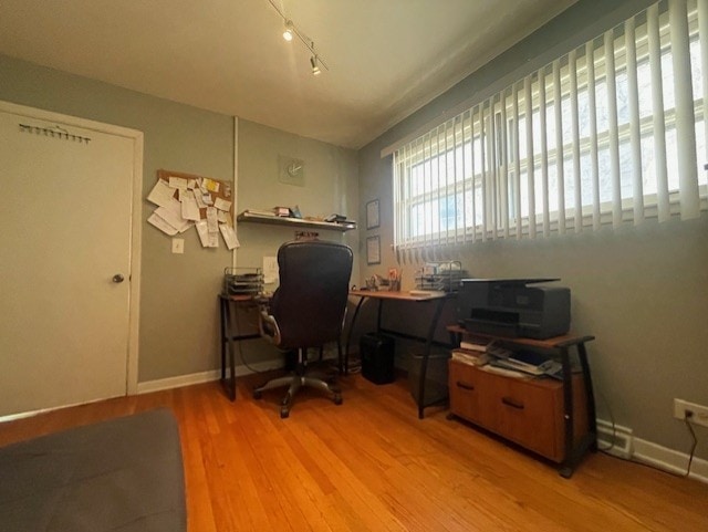 office space featuring light wood-type flooring and rail lighting