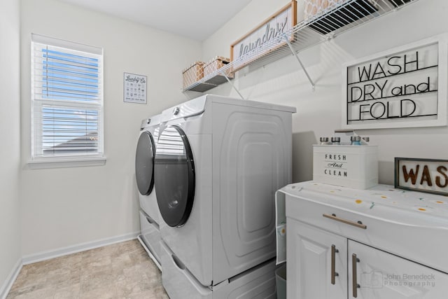 laundry room featuring washing machine and dryer and baseboards