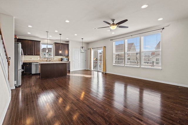 unfurnished living room with ceiling fan and dark hardwood / wood-style flooring