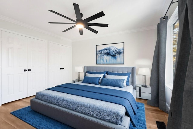 bedroom with hardwood / wood-style flooring, ceiling fan, and ornamental molding