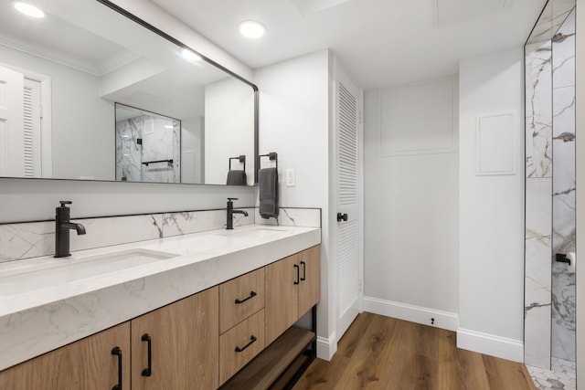 bathroom featuring vanity, a shower, wood-type flooring, and crown molding