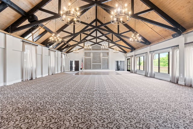 miscellaneous room with beam ceiling, high vaulted ceiling, and an inviting chandelier