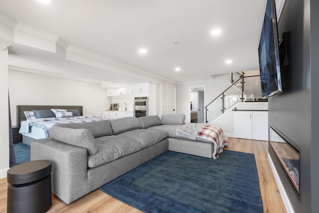 living room featuring wood-type flooring and crown molding