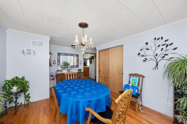 dining area with hardwood / wood-style floors and ornamental molding