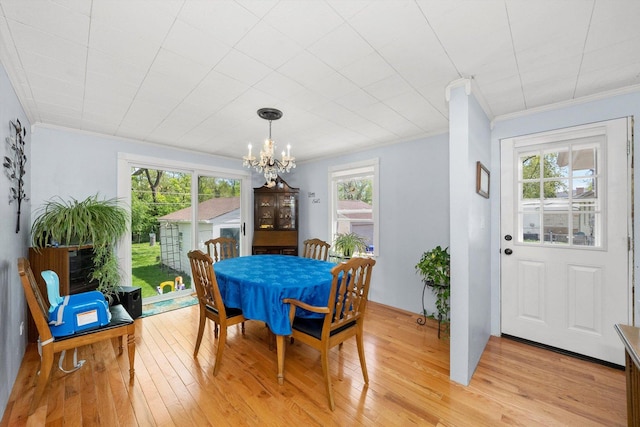 dining area featuring a chandelier, a healthy amount of sunlight, light hardwood / wood-style floors, and ornamental molding