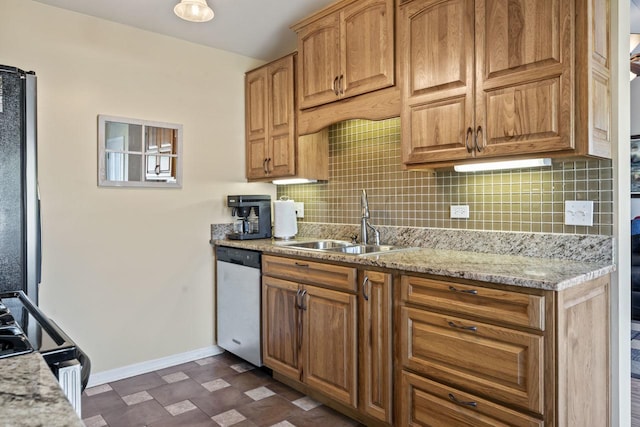 kitchen featuring backsplash, light stone countertops, sink, and appliances with stainless steel finishes