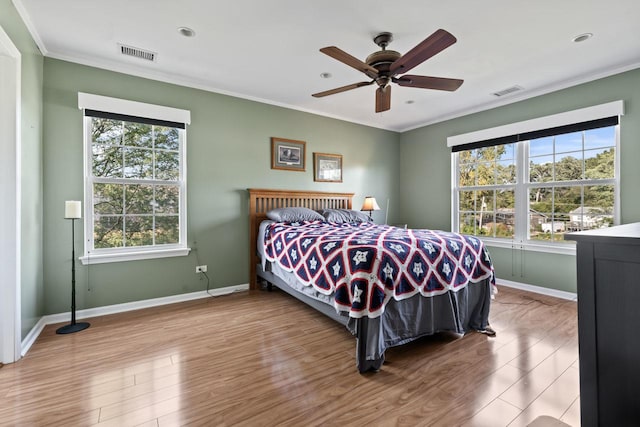 bedroom with ceiling fan, light hardwood / wood-style floors, and ornamental molding