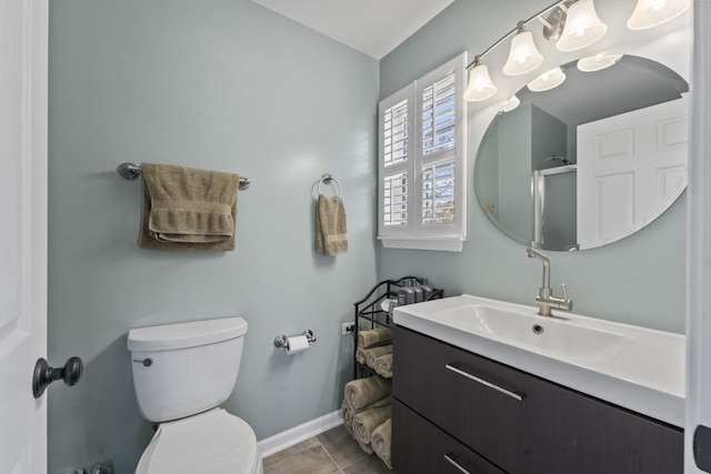 bathroom with tile patterned flooring, vanity, toilet, and a shower with door