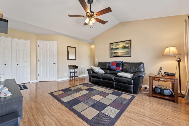 living room featuring hardwood / wood-style flooring, ceiling fan, and vaulted ceiling