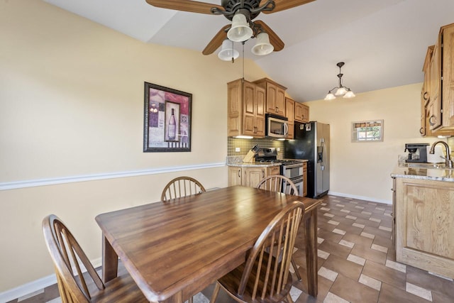 dining area with ceiling fan with notable chandelier, lofted ceiling, and sink