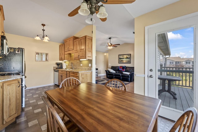 dining area featuring sink, a chandelier, and vaulted ceiling