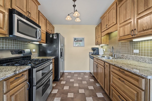 kitchen featuring appliances with stainless steel finishes, tasteful backsplash, sink, pendant lighting, and a chandelier