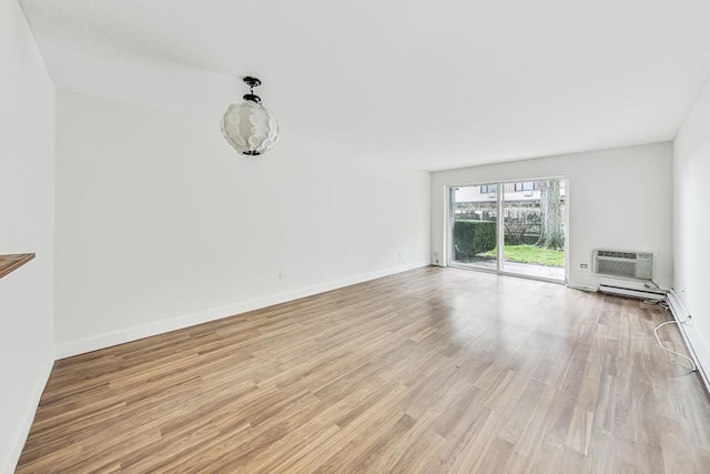 unfurnished living room with a wall mounted air conditioner and light hardwood / wood-style floors