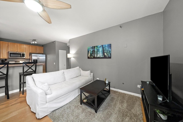 living room with ceiling fan and light hardwood / wood-style flooring