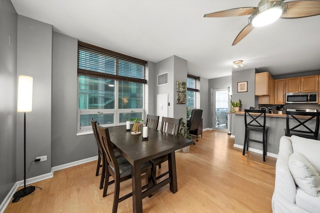 dining area with light hardwood / wood-style flooring and ceiling fan