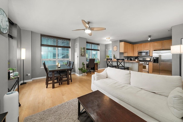 living room featuring light wood-type flooring and ceiling fan