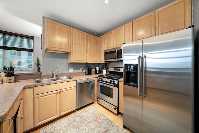 kitchen with sink, light hardwood / wood-style flooring, stainless steel appliances, and light brown cabinets