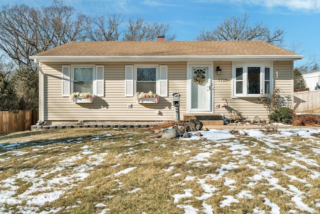 view of front of property featuring a shingled roof, a chimney, and fence