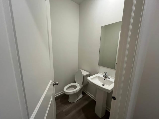 bathroom featuring hardwood / wood-style flooring and toilet