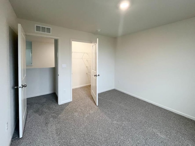 unfurnished bedroom featuring a spacious closet and carpet