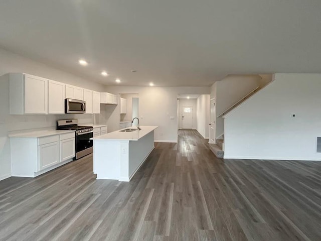 kitchen featuring sink, white cabinetry, a center island with sink, appliances with stainless steel finishes, and dark hardwood / wood-style flooring