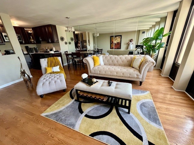 living room featuring light hardwood / wood-style floors and an inviting chandelier