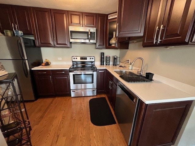 kitchen with sink, light wood-type flooring, and appliances with stainless steel finishes