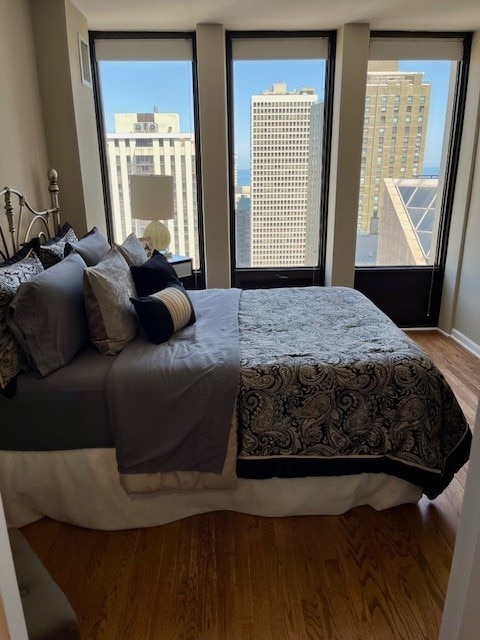 bedroom with hardwood / wood-style floors and multiple windows