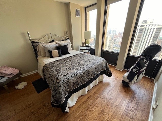 bedroom with wood-type flooring and multiple windows