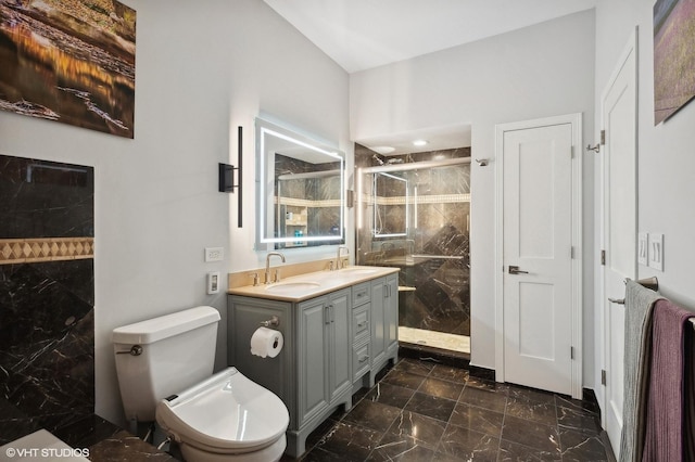 bathroom with a tile shower, vanity, and toilet