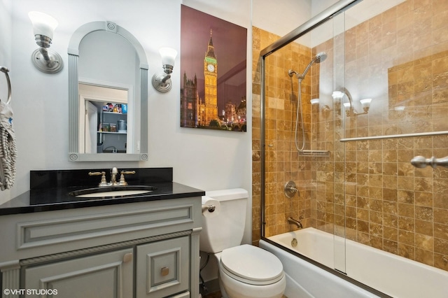 full bathroom with combined bath / shower with glass door, vanity, and toilet