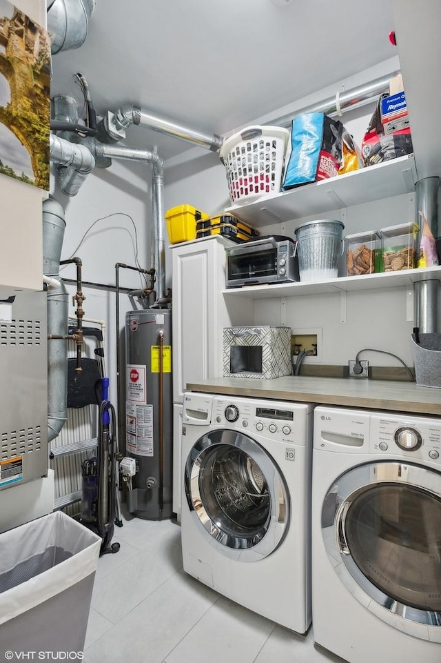 laundry room with washing machine and dryer, light tile patterned floors, and water heater