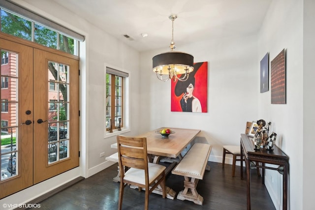 dining area featuring dark hardwood / wood-style floors, an inviting chandelier, and french doors