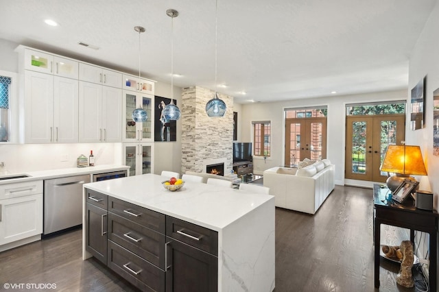 kitchen featuring white cabinetry, dishwasher, a center island, hanging light fixtures, and french doors