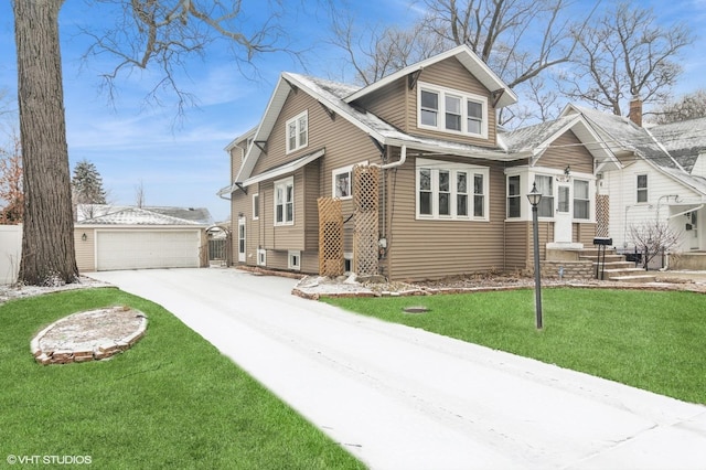 view of front of house with a garage, an outbuilding, and a front lawn