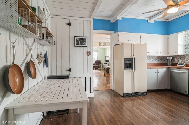 kitchen with dark hardwood / wood-style floors, stainless steel dishwasher, white fridge with ice dispenser, and wood walls