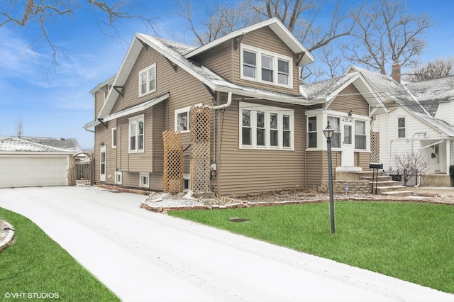 view of front of house with a garage, an outbuilding, and a front yard