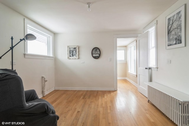 sitting room featuring radiator heating unit and light hardwood / wood-style flooring