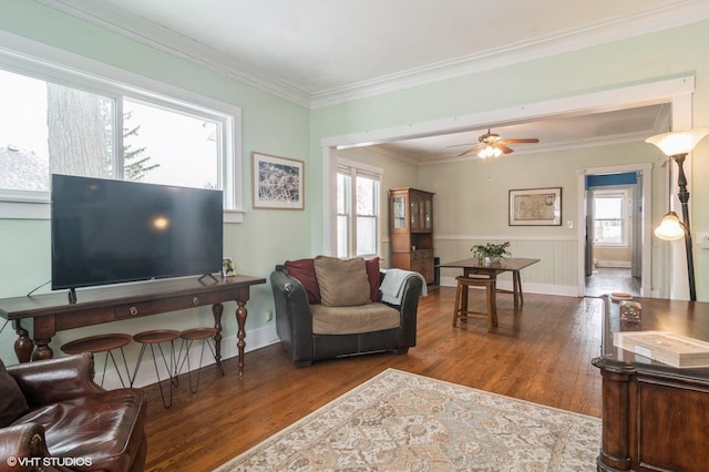 living room with crown molding, ceiling fan, and dark wood-type flooring